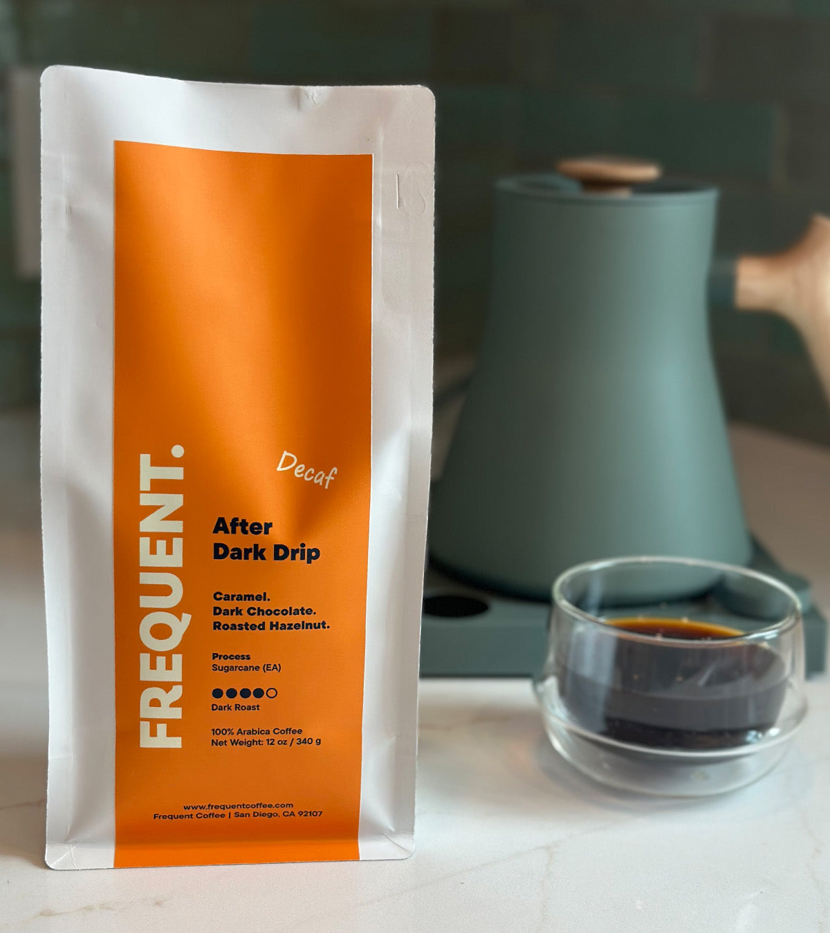 A bag of After Dark Drip Decaf Coffee from Frequent Coffee next to a coffee cup