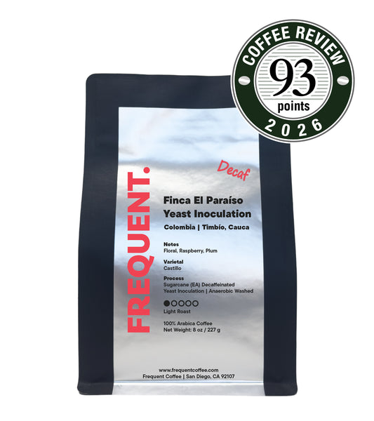 A bag of Frequent coffee decaf. Finca El Paraiso Yeast Inoculation coffee on a white background, featuring a black bag with a white label and a green and white 'Coffee Review 93 points 2026' badge in the top right corner.